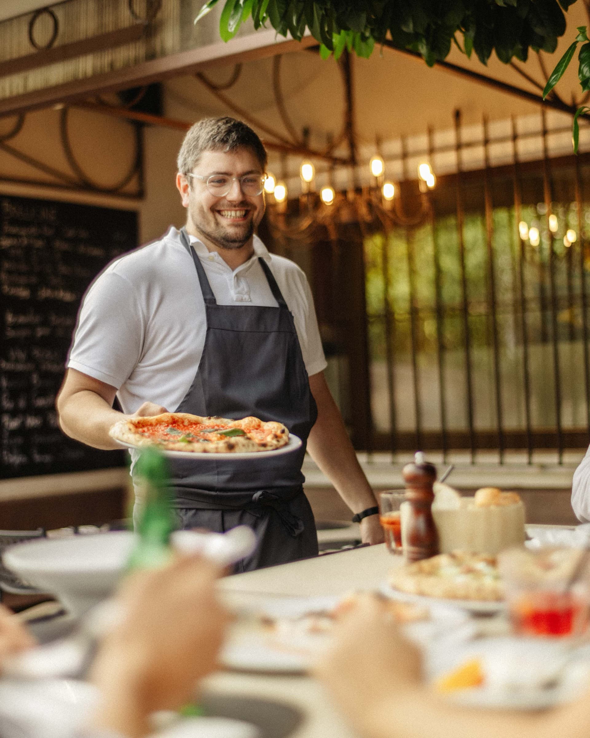 Michael reicht eine Pizza über den Tisch
